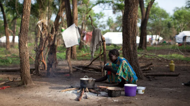 Uma mulher prepara um jantar simples de sorgo para sua família no campo de refugiados de Yusif Batil, no Sudão do Sul [Nichole Sobecki/MSF/AFP]