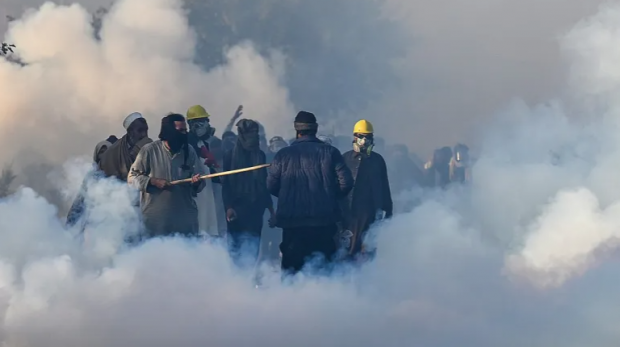 Policiais disparam bombas de gás lacrimogêneo para dispersar apoiadores do PTI durante um protesto em Islamabad, 26 de novembro de 2024 [Aamir Qureshi/AFP]