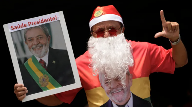 Um homem vestido de Papai Noel mostra seu apoio ao presidente Luiz Inácio Lula da Silva durante a hospitalização do líder em São Paulo, Brasil [Eraldo Peres / AP Photo]