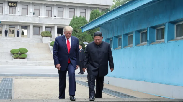 Trump e Kim cruzam uma linha de demarcação militar na Zona Desmilitarizada Coreana que separa as duas Coreias, em Panmunjom [KCNA via Reuters]