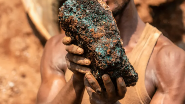 Um mineiro artesanal em Kolwezi, RDC, segura uma pedra de cobalto [Arquivo: Junior Kannah / AFP]