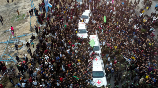 Pessoas se reúnem enquanto militantes terroristas do Hamas entregam reféns à Cruz Vermelha na Cidade de Gaza, em 19 de janeiro de 2025
(crédito da foto: REUTERS/MAHMOUD AL-BASOS)