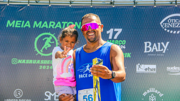 Gileno, emocionado, recebe uma medalha enquanto segura sua filha no colo. O momento simboliza não apenas a conquista pessoal, mas também o equilíbrio entre suas responsabilidades como atleta, trabalhador e pai. Foto: Redes Sociais/Reprodução