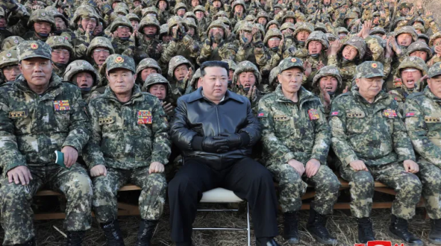 O líder norte-coreano Kim Jong Un posa com tropas [Arquivo: KCNA / Reuters]