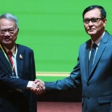 Ministro cambojano responsável pela Secretaria de Estado de Assuntos de Fronteira, Lam Chea (à direita), aperta a mão do Conselheiro de Assuntos de Fronteira da Tailândia no Ministério das Relações Exteriores, Prasas Prasasvinitchai, durante uma reunião da comissão conjunta cambojana-tailandesa sobre a demarcação da fronteira terrestre em Phnom Penh, Camboja, em 14 de junho de 2025 [Heng Sinith/AP]