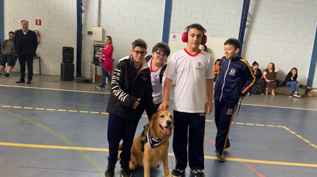 Alunos da E.M. “Prof. Flávio de Souza Nogueira” interagem com o cão-terapeuta Buddy durante ação do projeto “Tô de boa… Drogas nem pensar!”. Fotos: Rose Campos (Secom) e Sedu/Divulgação