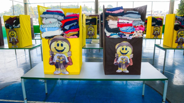 Moradores do Recanto das Rosas participam da segunda edição do Bazar Solidário, que ofereceu roupas, alimentos e educação financeira, onde crianças aprenderam sobre o valor do dinheiro usando cédulas fictícias. Imagens: Francisco Cepeda