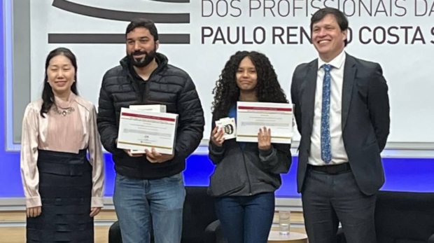 Estudantes premiados celebram conquista durante cerimônia na EFAPE, em São Paulo, marcando a união cultural entre Brasil e China. Autoridades, professores e alunos juntos no palco da premiação do concurso que reuniu mais de 12 mil redações em todo o Estado. Foto: Ibrachina