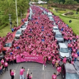 #ParaQueTodosPossamVer: A imagem mostra um grupo animado de pessoas vestidas de rosa caminhando pelas ruas da cidade, segurando faixas e balões que simbolizam a conscientização e o apoio à causa. Foto: Prefeitura De Santana De Parnaíba (Redes Sociais/Reprodução)