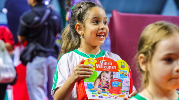 Crianças da rede municipal de ensino recebem brinquedos da ação Natal Mágico 2025 durante evento no Ginásio José Liberatti. Fotos: Secom