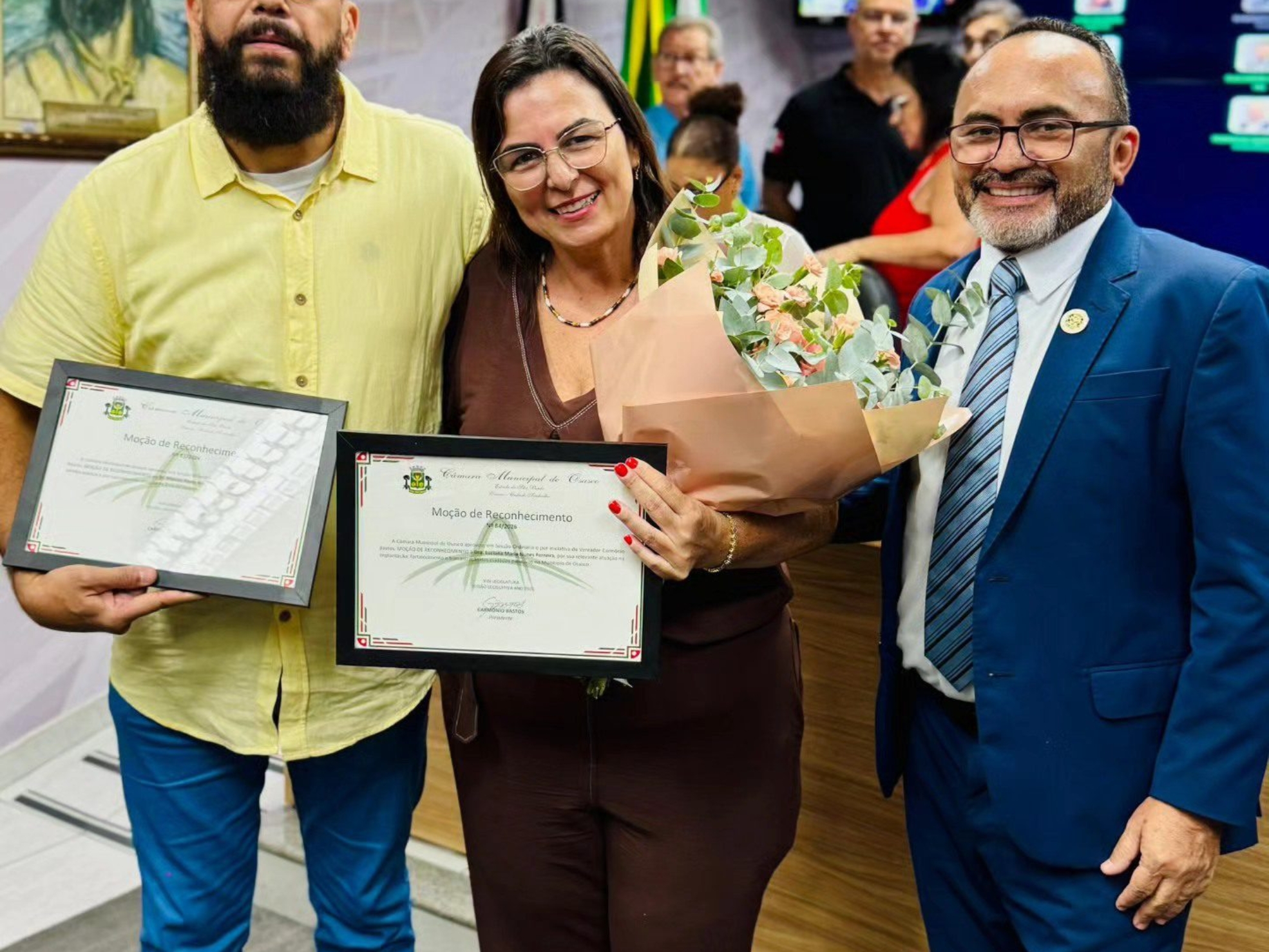 O gestor Marcos Paulo Machado e a médica Luciana Maria Nunes Ferreira recebem reconhecimento ao lado do vereador Carmônio Bastos pela atuação humanizada na saúde pública de Osasco. Foto: Câmara De Osasco