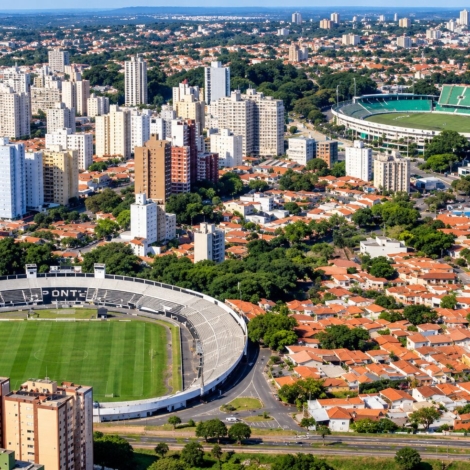 Ilustração: Vista aérea representativa da paisagem urbana de Campinas e de seus estádios de futebol. O momento vivido por Ponte Preta e Guarani reacende o debate sobre a importância do futebol para a identidade da cidade e suas oportunidades de projeção nacional, turismo e negócios.